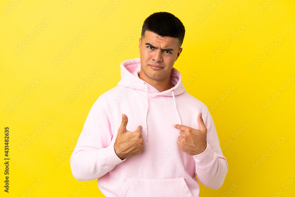 Young handsome man over isolated yellow background pointing to oneself Young handsome man over isolated yellow background pointing to oneself