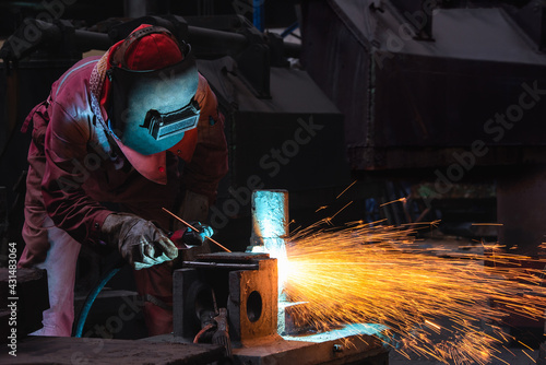 Welder use carbon air arc gouging for hot work cutting or gouging heavy metal steel structure in the fabrication factory. photo