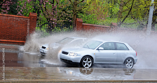 Samochód wpada w kałużę wody na jezdni powodująć rozbryzg. 