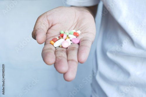  multi color medical pills and capsule on palm of hand 