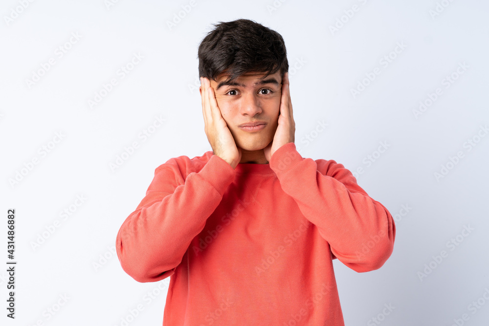 Handsome man over isolated blue background frustrated and covering ears Handsome man over isolated blue background frustrated and covering ears