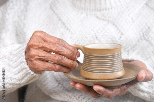 senior women hand holding a cup of green tea 