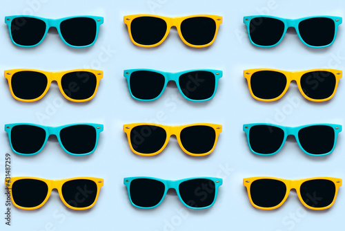 Top view of creative pattern made of blue and yellow sunglasses