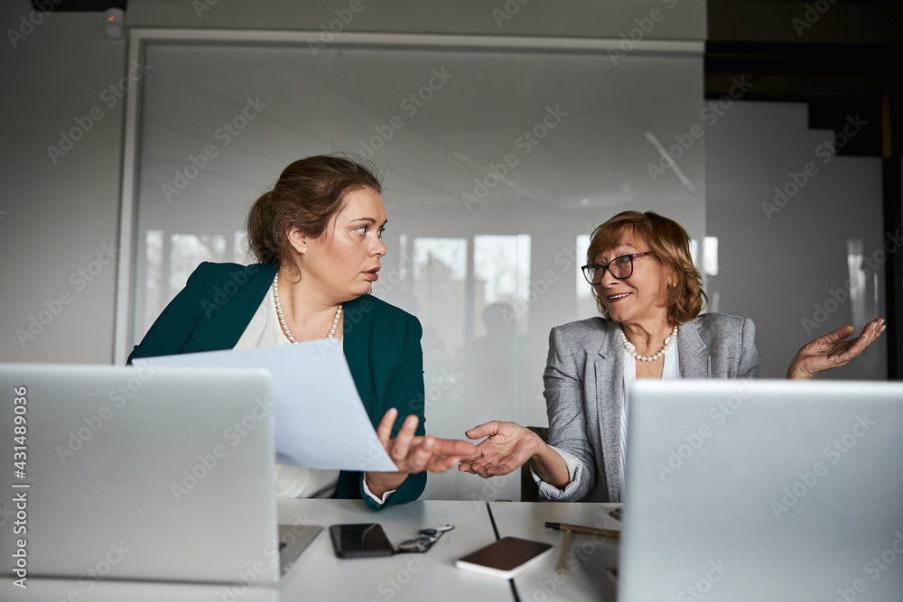 Businesswoman having no idea about meaning of information on document Businesswoman having no idea about meaning of information on document