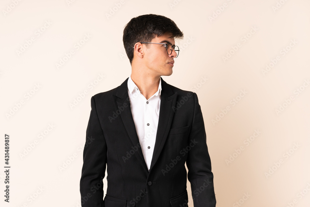 Businessman over isolated beige background looking side Businessman over isolated beige background looking side