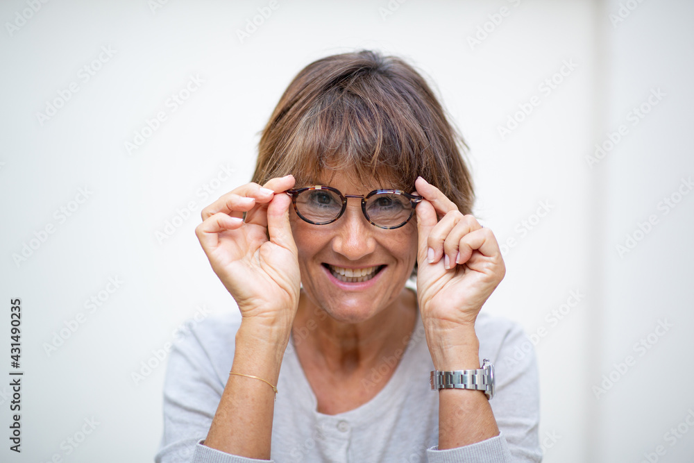 Close up older woman smiling with eyeglasses by white background Close up older woman smiling with eyeglasses by white background