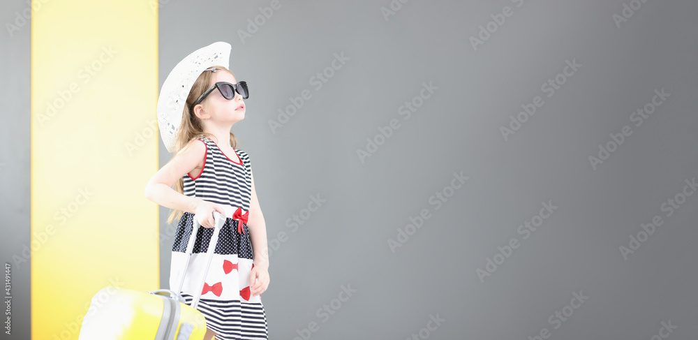 Little girl in sunglasses and hat walking with suitcase in her hand Little girl in sunglasses and hat walking with suitcase in her hand