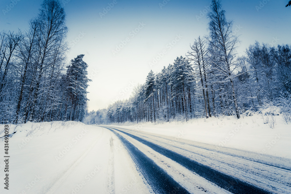 Snowfall on a winter day, snow-covered country road. View from the side of the road. Coniferous forest. Russia, Europe. Beautiful nature. Snowfall on a winter day, snow-covered country road. View from the side of the road. Coniferous forest. Russia, Europe. Beautiful nature.