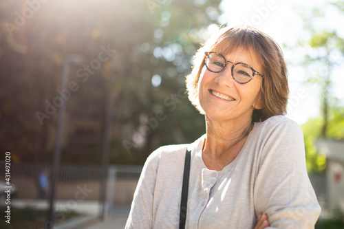 Close up older woman with eyeglasses smiling outside photo