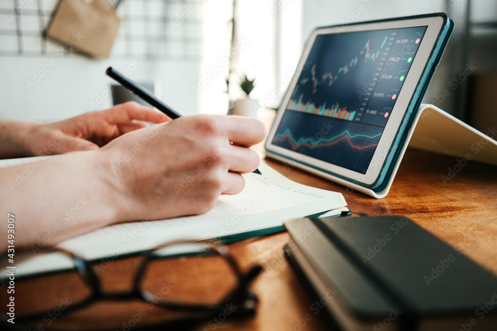 Naklejka premium Woman working with investment stock market using tablet computer; analyzing trading data. Close-up