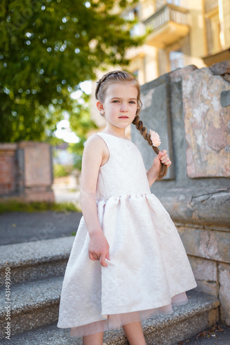 Beautiful young girl in white dress and pretty hairstyle