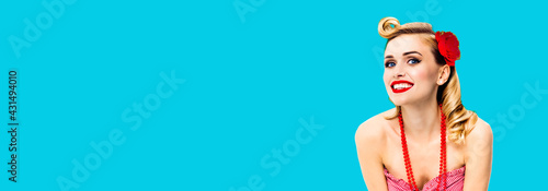 Excited surprised, happy smiling beautiful woman. Portrait of pin up blond girl at studio. Retro and vintage concept picture. Aqua blue color background. Wide banner composition. © vgstudio
