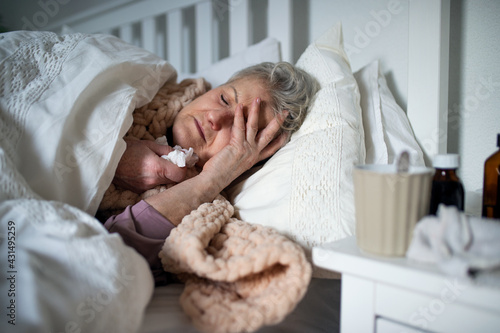 Valokuvatapetti Sick senior woman sleeping in bed at home, cold and flu concept.