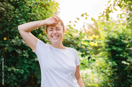 Young woman smiling outdoor. Beautiful brunete girl resting on park or garden green background. Free happy woman at summertime. Freedom happiness carefree happy people concept.