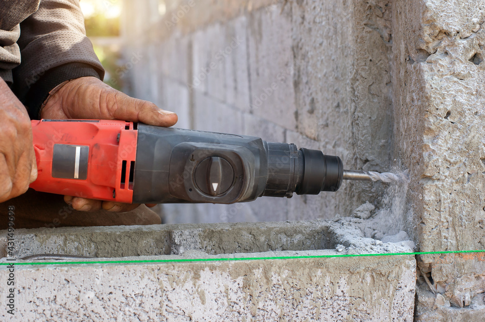 Construction worker drilling a drill on concrete