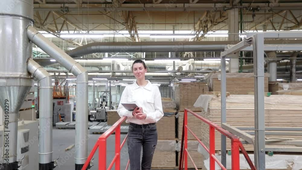 Business woman portrait in the carpentry factory using tablet pc. Carpentry factory. Factory for the production of parquet board Business woman portrait in the carpentry factory using tablet pc. Carpentry factory. Factory for the production of parquet board