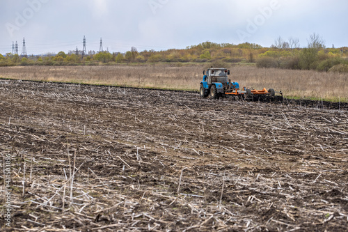 Tractor Plowing Field Tillage Agricultural land Farm Agriculture Preparing the soil for sowing. Plow Machine Equipment Working Village Season