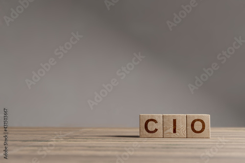 Wood cubes with acronym 'CIO' - 'Chief Information Officer' on a beautiful wooden table, studio background. Business concept and copy space. photo