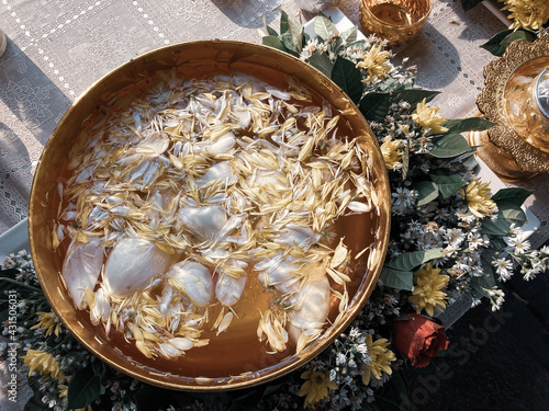 Flower petals in Thai-styled golden bowl filled with water for Songkran festival