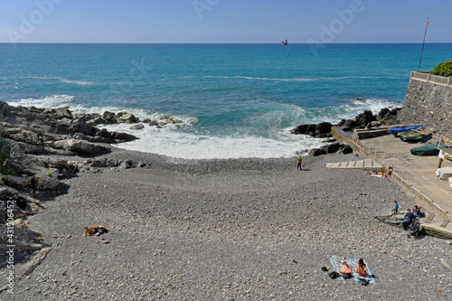 A Genova Nervi in una soleggiata mattina di primavera alcune persone prendono il sole in una incantevole e caratteristica insenatura della costiera ligure.  photo