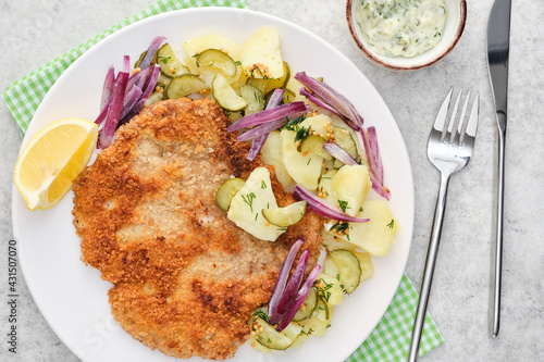 Vienna schnitzel with potatoes and onions.