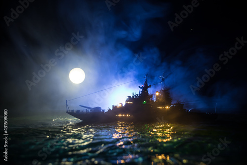 Silhouettes of a crowd standing at blurred military war ship on foggy background. Selective focus.