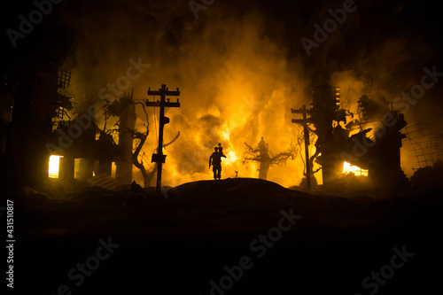 Silhouette of a man carrying injured girl from fire. Rescue savior concept. Military officer running out with woman from burned out city destroyed in war. Creative artwork decoration. Selective focus