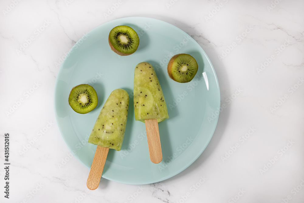 Frozen fruit kiwi juice in a bowl. refreshing Popsicle on a stick. Top view, copy space Frozen fruit kiwi juice in a bowl. refreshing Popsicle on a stick. Top view, copy space