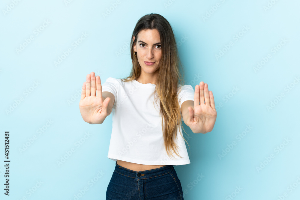 Young caucasian woman over isolated background making stop gesture and disappointed Young caucasian woman over isolated background making stop gesture and disappointed