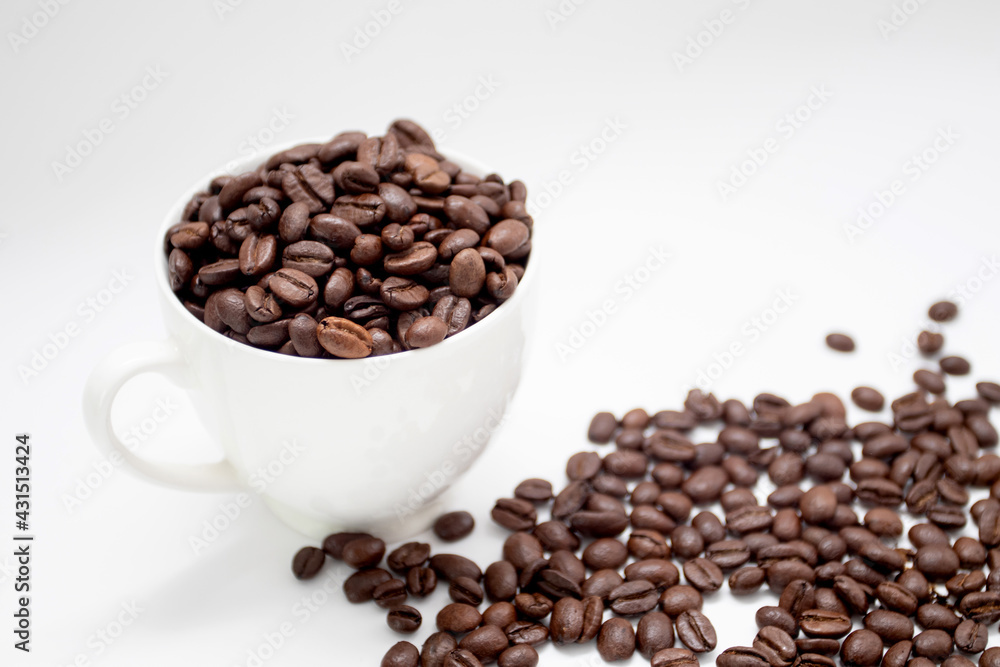 Roasted coffee beans in white cup with roasted coffee beans on white background Roasted coffee beans in white cup with roasted coffee beans on white background
