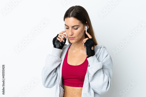 Young sport woman over isolated background listening music