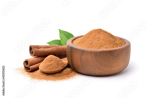 Leinwand Poster Aromatic cinnamon powder in wooden bowl with sticks on white background