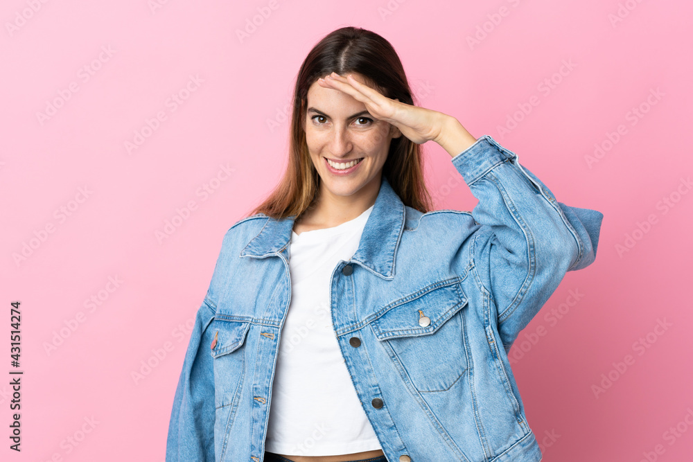 Young caucasian woman isolated on pink background saluting with hand with happy expression Young caucasian woman isolated on pink background saluting with hand with happy expression