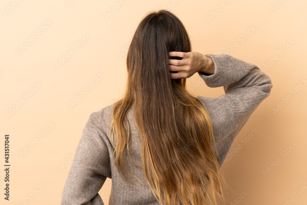 Young caucasian woman over isolated background in back position and thinking Young caucasian woman over isolated background in back position and thinking