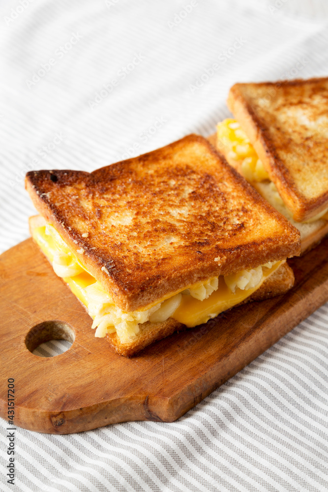 Homemade Grilled Macaroni and Cheese Sandwich on a rustic wooden board on a white wooden background, low angle view. Homemade Grilled Macaroni and Cheese Sandwich on a rustic wooden board on a white wooden background, low angle view.
