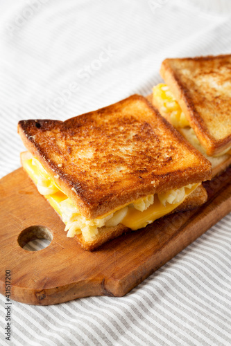 Homemade Grilled Macaroni and Cheese Sandwich on a rustic wooden board on a white wooden background, low angle view.