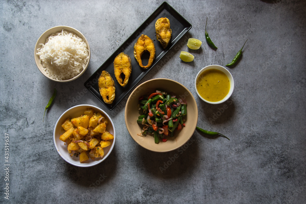 Indian lunch food ingredients rice fish vegetables and pulses with use of selective focus. A pure Bengali cuisine Indian lunch food ingredients rice fish vegetables and pulses with use of selective focus. A pure Bengali cuisine