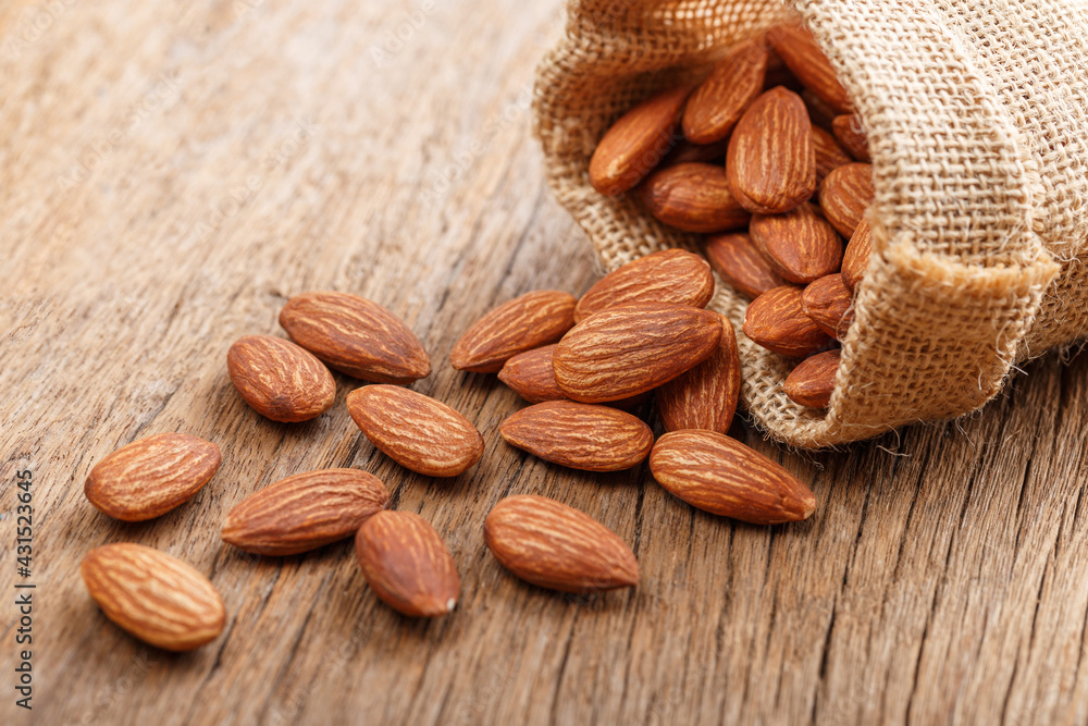 Almond snack fruit in a brown sack on a wooden floor Almond snack fruit in a brown sack on a wooden floor