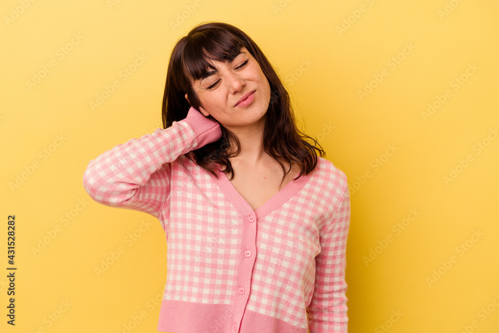 Young caucasian woman isolated on yellow background having a neck pain due to stress, massaging and touching it with hand. Young caucasian woman isolated on yellow background having a neck pain due to stress, massaging and touching it with hand.