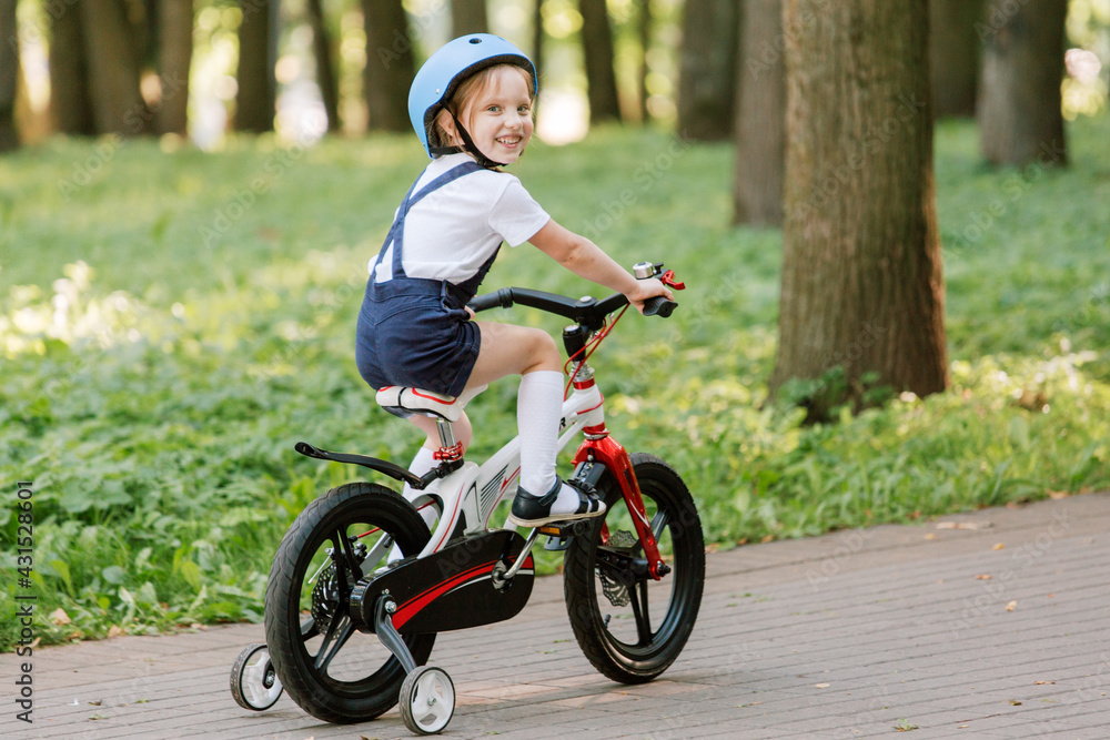 Cheerful smiling girl in helmet on bicycle. Cheerful smiling girl in helmet on bicycle.