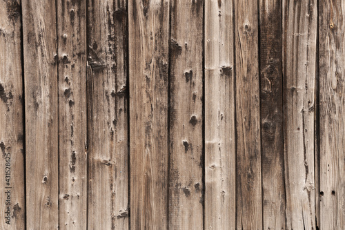 Brown wood background from wood planks of natural solid wood. Cracks and knots present. Collected vertical boards
