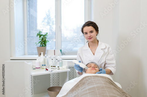 Girl lying on a couch gets skin cleaning in a cosmetology and beauty salon