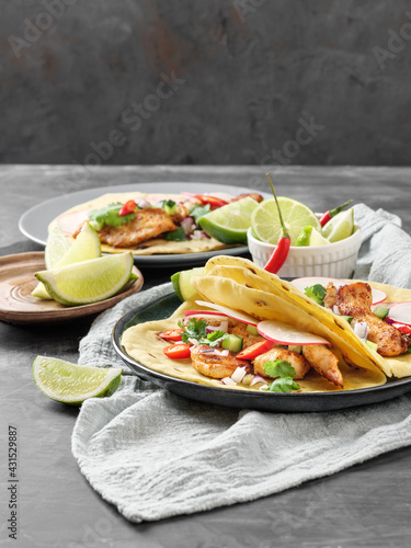 Tacos with chicken, vegetables and lime on the table.