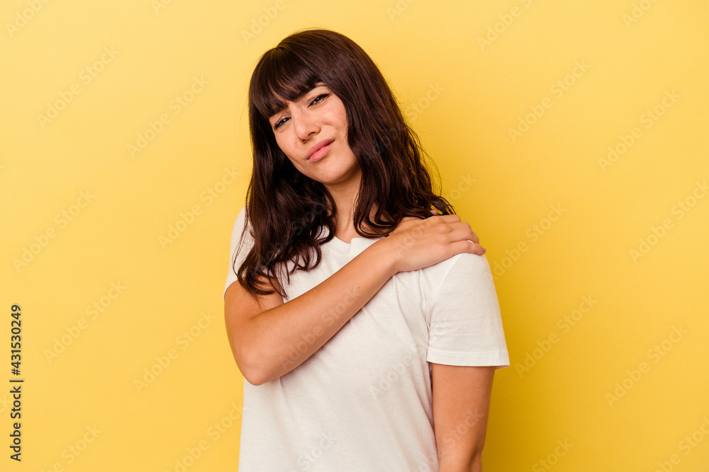 Obraz premium Young caucasian woman isolated on yellow background having a shoulder pain.
