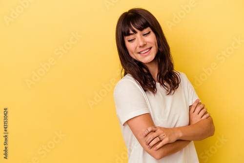 Young caucasian woman isolated on yellow background smiling confident with crossed arms. © Asier