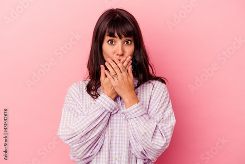 Young caucasian woman isolated on pink background shocked covering mouth with hands.