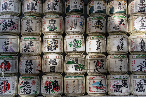 Traditional Sake barrels at the entrance to Meiji shrine in Tokyo.. The writings in Japanese inform of the content of barrels and religious verses © Shootdiem