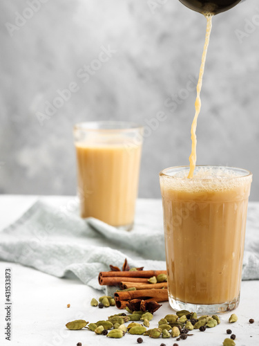 Traditional Indian drink Masala tea on a light background with spices.