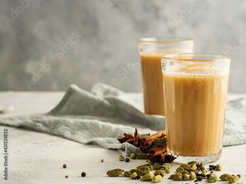 Traditional Indian drink Masala tea on a light background with spices.