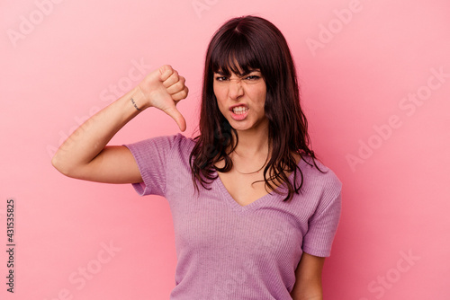 Young caucasian woman isolated on pink background showing thumb down and expressing dislike.